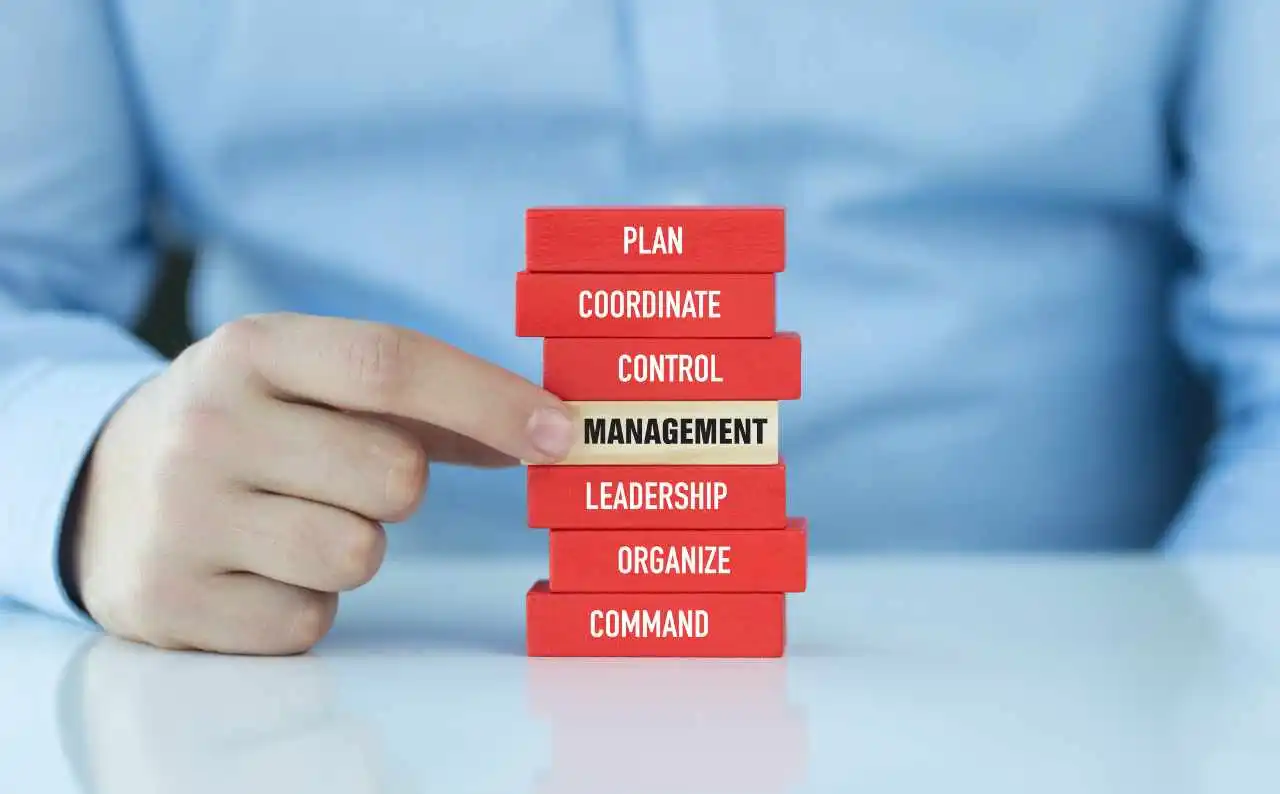 Immagine di una mano che inserisce un blocco management in una pila di altri valori