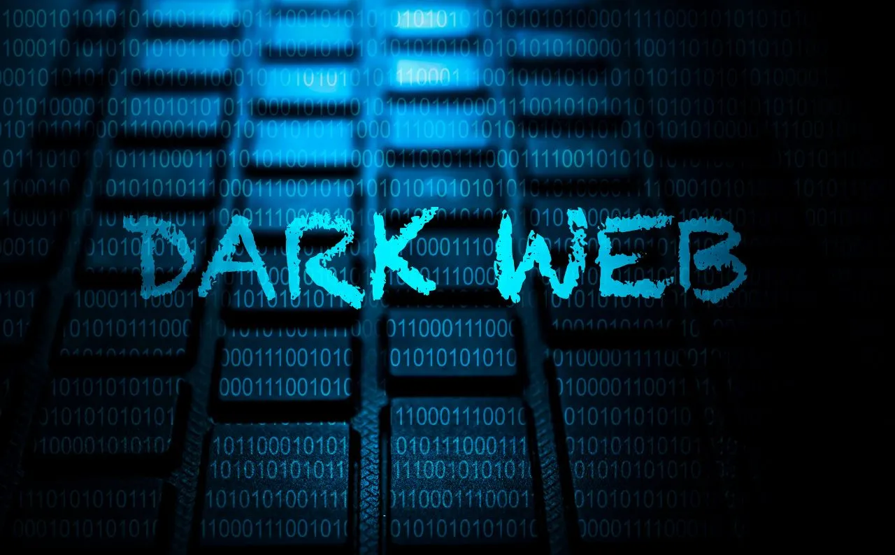Immagine con tastiera al buio e una scritta dark web