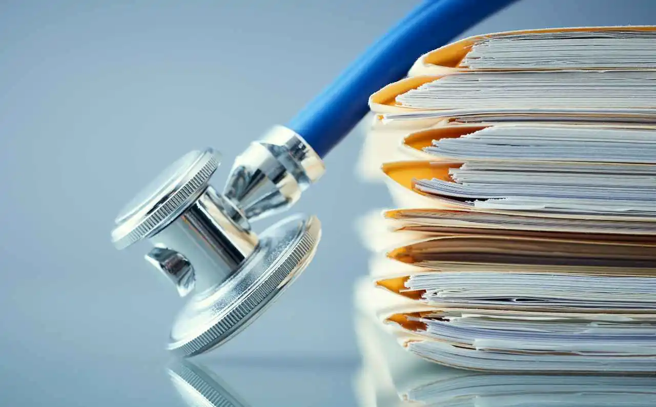 Immagini con fascicoli sanitari cartacei e uno stetoscopio